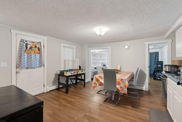 dining area featuring a textured ceiling, wood finished floors, a baseboard radiator, and ornamental molding