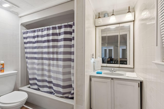 bathroom featuring vanity, visible vents, shower / tub combo, tile walls, and toilet