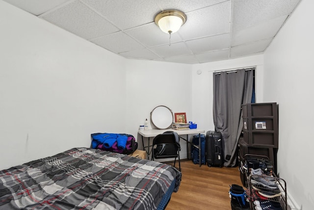 bedroom featuring wood finished floors and a paneled ceiling