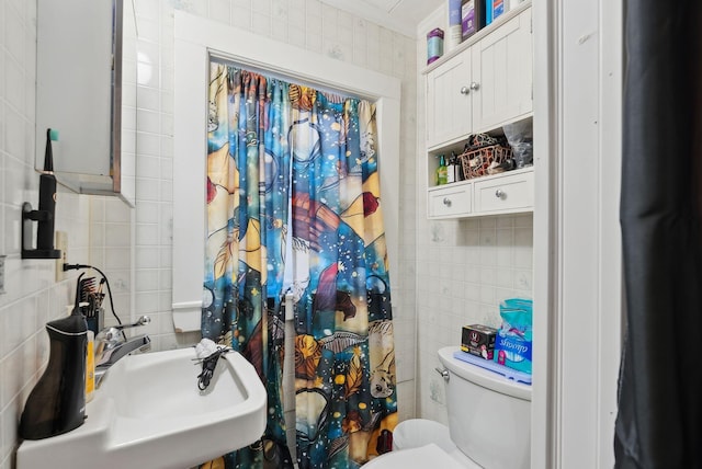 full bathroom with a sink, a shower with shower curtain, toilet, and tile walls