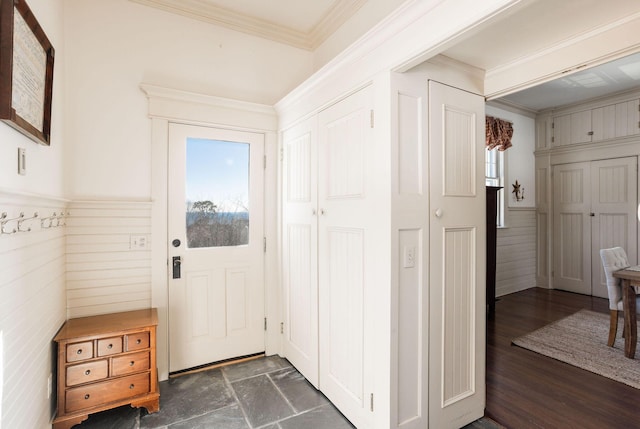 doorway to outside featuring ornamental molding, dark wood-style flooring, and wainscoting