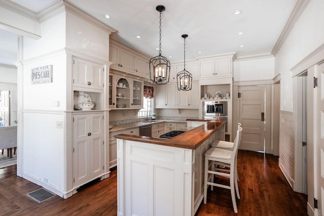 kitchen with ornamental molding, dark wood finished floors, and a center island