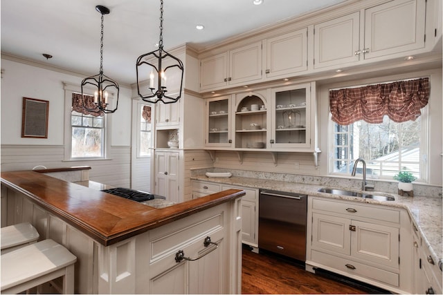 kitchen with dark wood-style floors, a wainscoted wall, crown molding, appliances with stainless steel finishes, and a sink