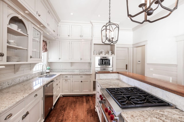 kitchen featuring open shelves, an inviting chandelier, appliances with stainless steel finishes, white cabinetry, and a sink