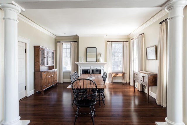 dining area featuring dark wood-style floors, a fireplace, decorative columns, and ornamental molding