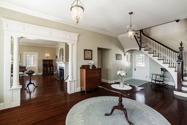 entrance foyer featuring arched walkways, a fireplace, stairs, hardwood / wood-style floors, and decorative columns