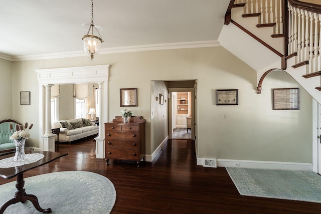 entryway with stairs, wood finished floors, visible vents, and crown molding