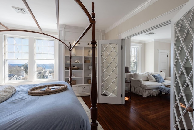 bedroom featuring visible vents, crown molding, and wood finished floors