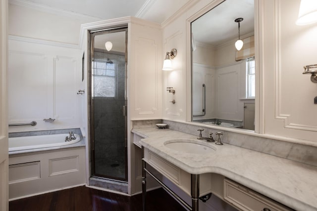 bathroom featuring a stall shower, ornamental molding, wood finished floors, vanity, and a bath