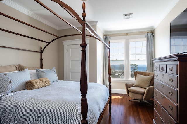 bedroom with ornamental molding, dark wood-style flooring, visible vents, and baseboards