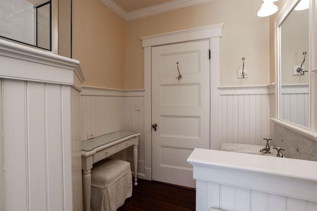 bathroom featuring wainscoting, crown molding, vanity, and wood finished floors