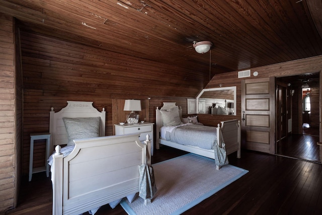 unfurnished bedroom featuring visible vents, hardwood / wood-style flooring, wood ceiling, vaulted ceiling, and wood walls