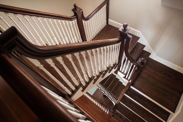 stairway with wood finished floors and baseboards