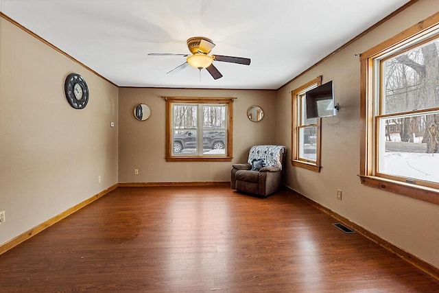 unfurnished room featuring baseboards, crown molding, visible vents, and wood finished floors