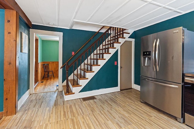 kitchen with wainscoting, stainless steel refrigerator with ice dispenser, and wood finished floors