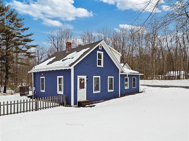 view of front facade with fence and a chimney