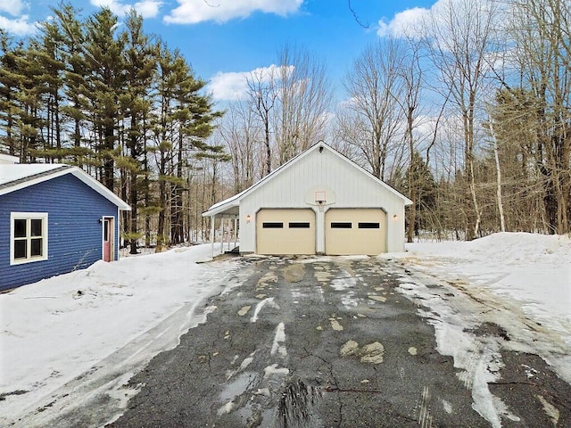 snow covered garage featuring a garage