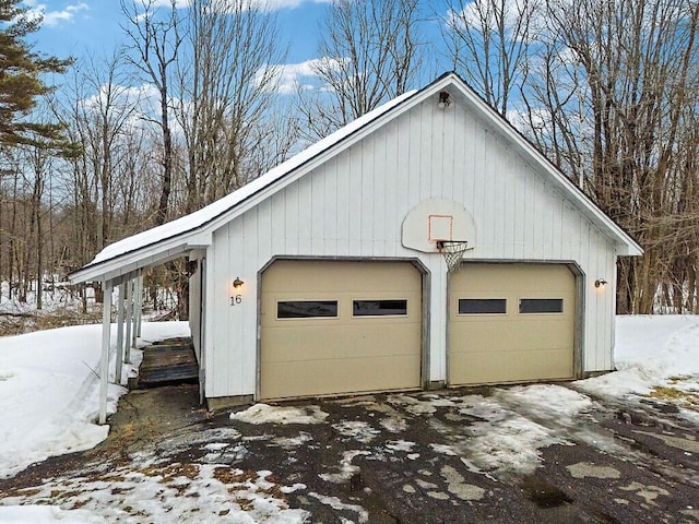 snow covered garage with a detached garage