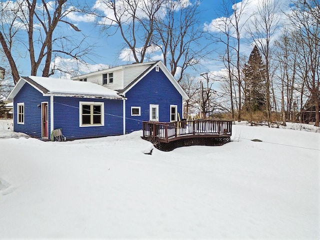 snow covered rear of property featuring a wooden deck