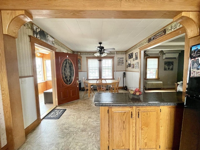 kitchen featuring dark countertops, radiator heating unit, a peninsula, and a ceiling fan