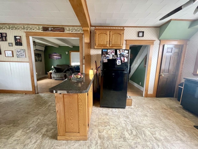 kitchen with wallpapered walls, baseboards, ornamental molding, brown cabinets, and freestanding refrigerator