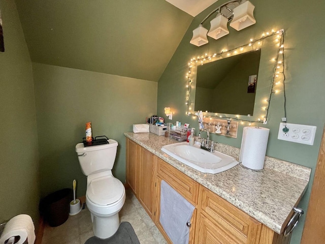 bathroom with lofted ceiling, vanity, and toilet