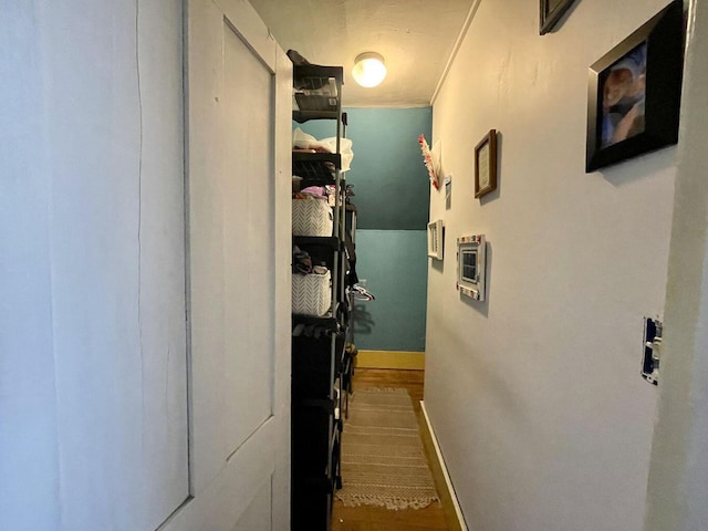 corridor featuring wood finished floors and baseboards