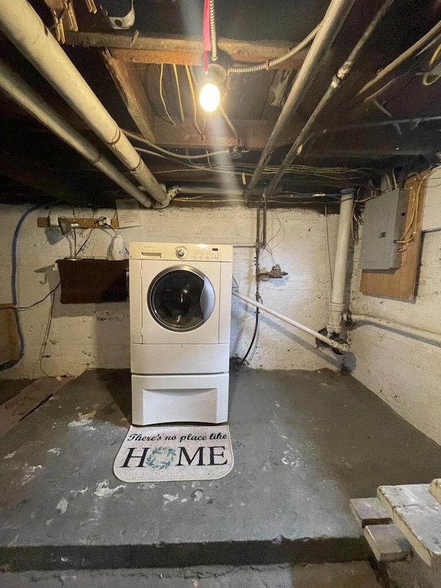 unfinished basement featuring washer / dryer and electric panel