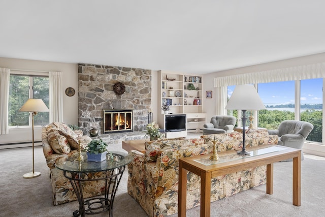 living area featuring a baseboard radiator, a healthy amount of sunlight, carpet flooring, and a stone fireplace