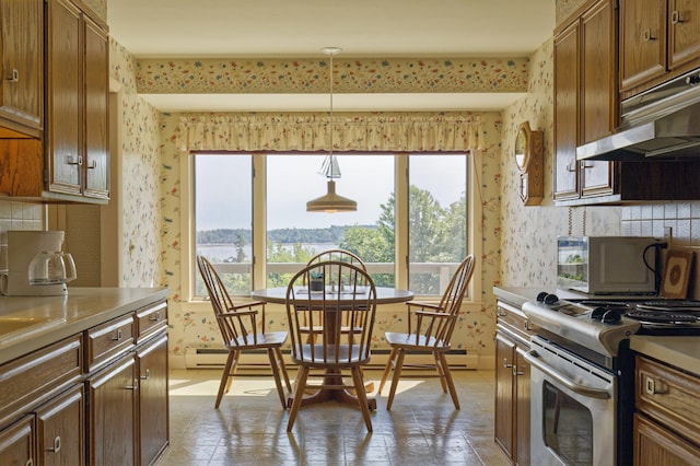 kitchen featuring wallpapered walls, under cabinet range hood, brown cabinetry, and electric stove