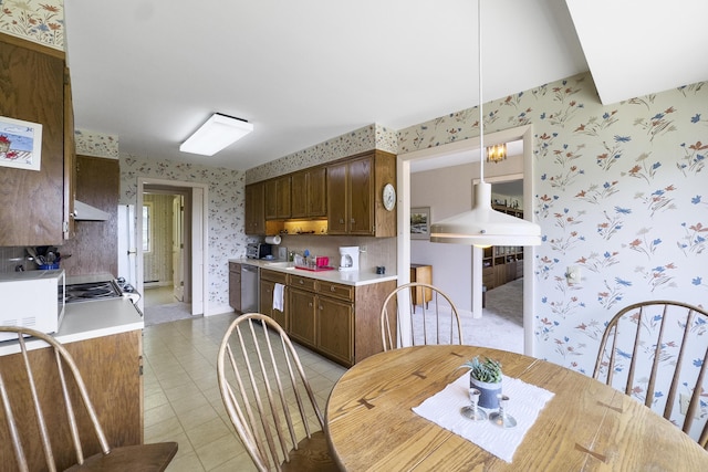 dining room with light tile patterned floors, baseboards, and wallpapered walls