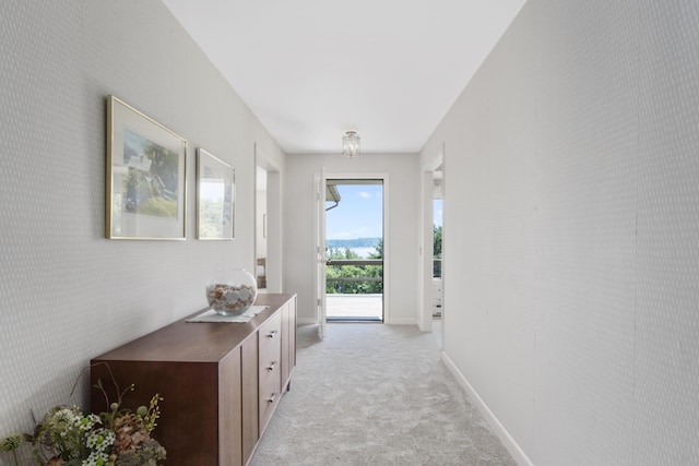 doorway with light colored carpet and baseboards