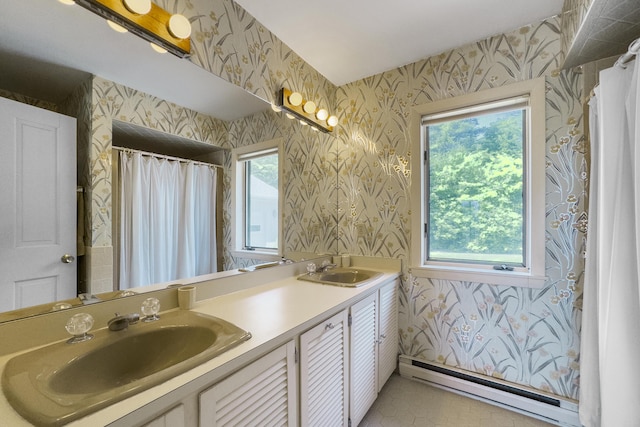 bathroom featuring double vanity, a baseboard radiator, a sink, and wallpapered walls