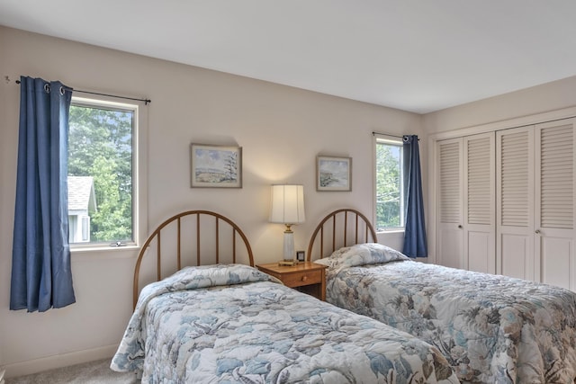 carpeted bedroom featuring a closet and baseboards