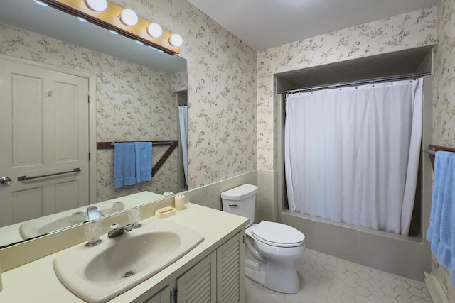 bathroom with wallpapered walls, toilet, a wainscoted wall, tile patterned floors, and vanity