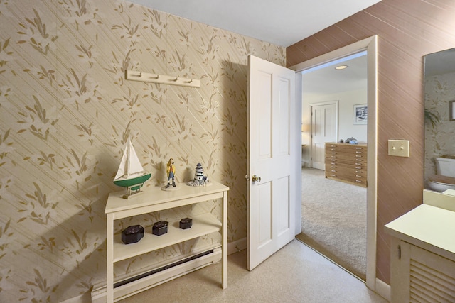 hallway with light carpet and wallpapered walls