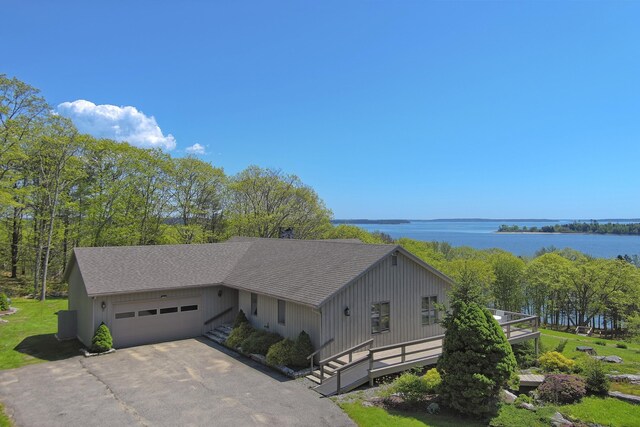 153 Back Shore Rd, Bristol, ME 04564 - view of front of house with an attached garage, roof with shingles, driveway, and a water view
