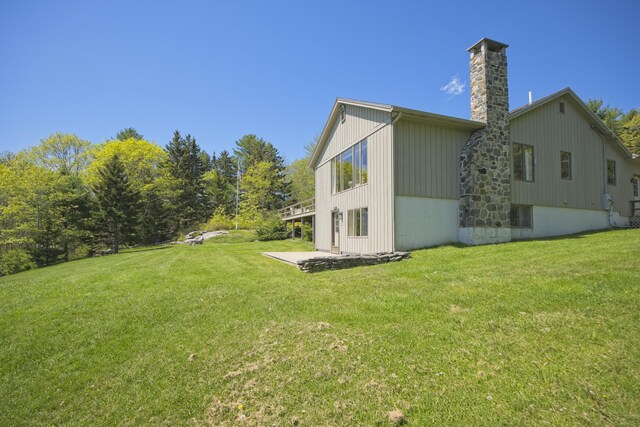 153 Back Shore Rd, Bristol, ME 04564 - view of side of home with a chimney, a lawn, and a patio