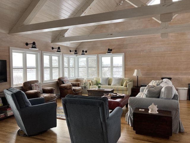 living room with lofted ceiling with beams, wooden walls, wood finished floors, and wooden ceiling