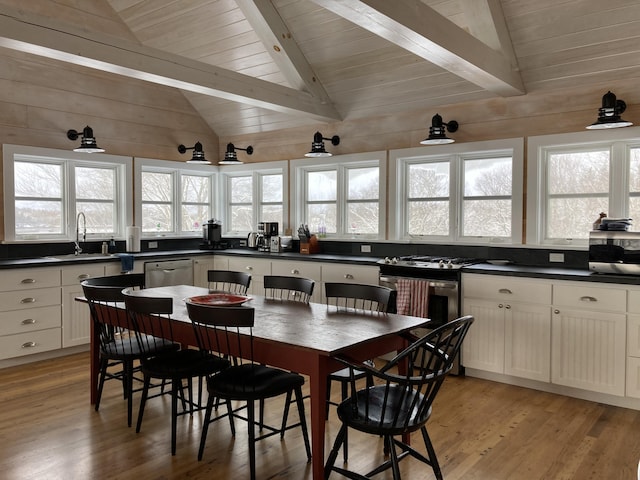 dining area featuring light wood-type flooring, plenty of natural light, wooden ceiling, and vaulted ceiling with beams