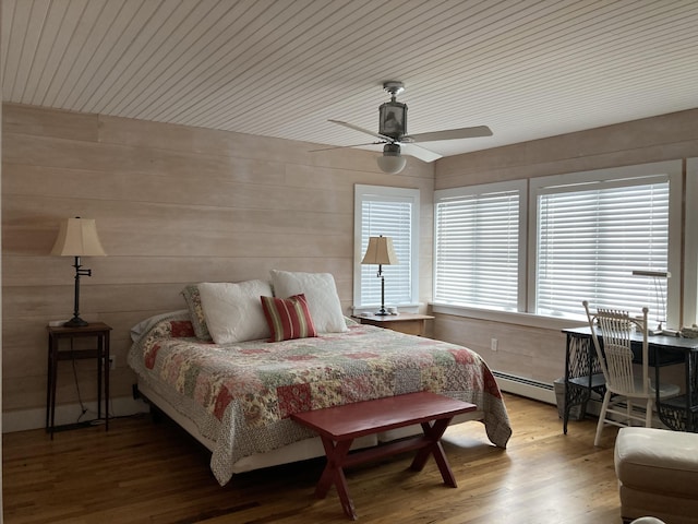 bedroom with ceiling fan, wooden walls, wood finished floors, and wooden ceiling