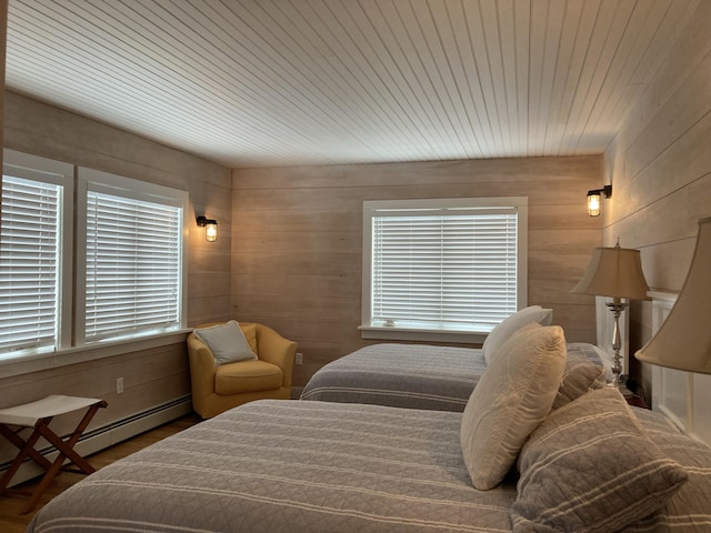 bedroom with a baseboard radiator, wood ceiling, and wood walls