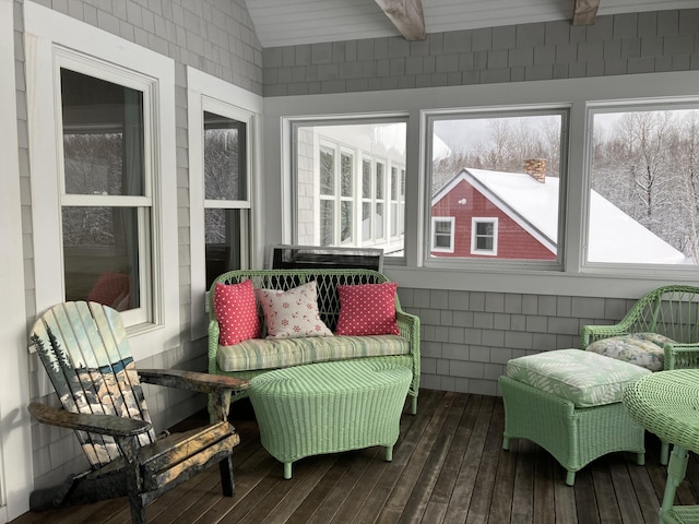 sunroom / solarium featuring vaulted ceiling with beams