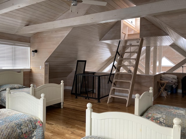 bedroom with lofted ceiling with beams, wood finished floors, wood walls, and wooden ceiling