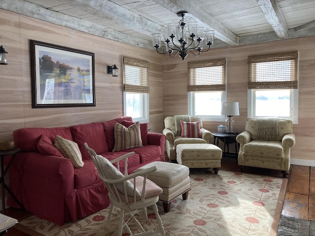 living area featuring wooden walls, a chandelier, beam ceiling, wooden ceiling, and wood finished floors