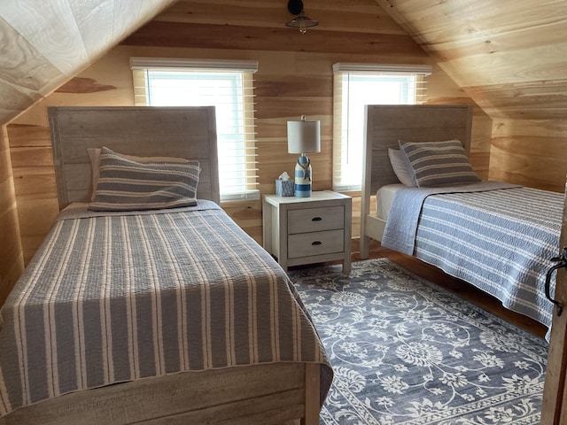 bedroom with multiple windows, wooden walls, and lofted ceiling