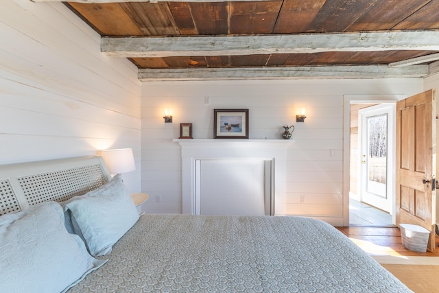 bedroom featuring beamed ceiling, wood ceiling, and wood finished floors