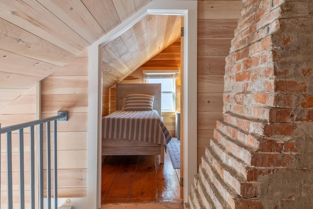 unfurnished bedroom featuring wooden walls, wood ceiling, lofted ceiling, and hardwood / wood-style floors