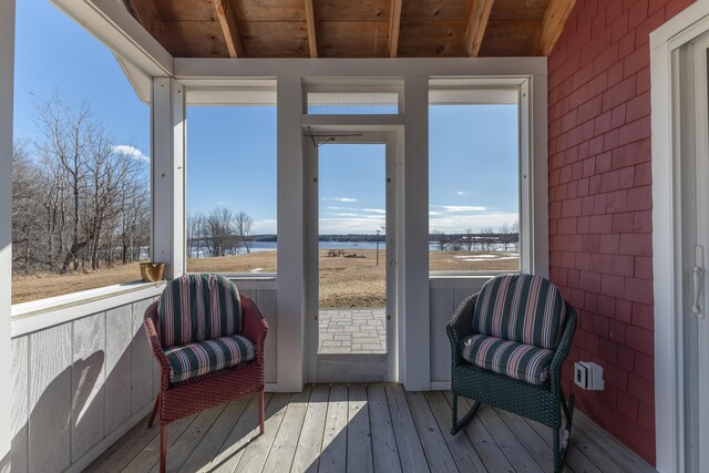 sunroom featuring wooden ceiling, a water view, and a wealth of natural light