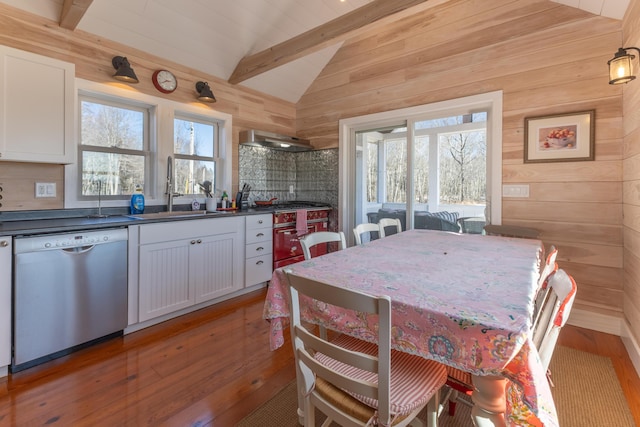 dining area with wooden walls, vaulted ceiling with beams, and light wood finished floors